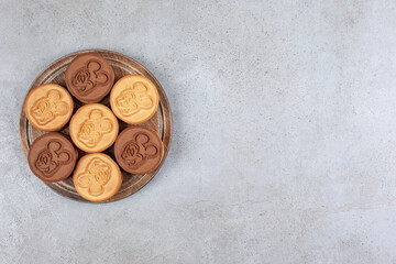 Appetizing bundle of cookies on wooden board on marble background