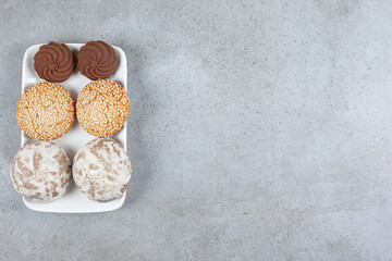 A variety of homemade cookies on a plate on marble background