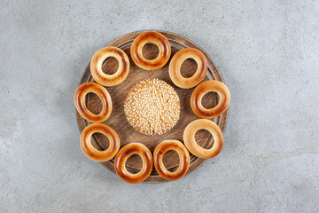 Single cookie surrounded by sushki on a wooden board on marble background