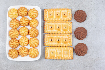 Cookies and biscuits lined up in a plate and on marble background