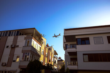 Fototapeta na wymiar A passenger plane comes in to land over the residential areas of the city of Antalya.