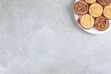 Tart cookies on decorated plate on marble background