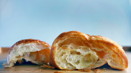 Close up a torn croissant, cross section of golden fresh baked French Croissant bakery, on wooden...