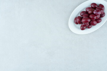 Pickled cornel cherries on white plate