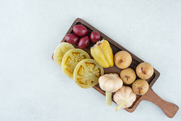 Assortment of tasty fermented vegetables on wooden board