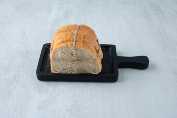 White bread tied with rope on dark board