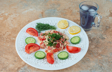 A white plate with vegetables and cup of juice