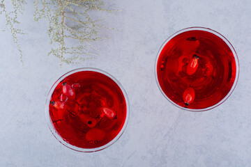 Two glasses of red juice on stone background