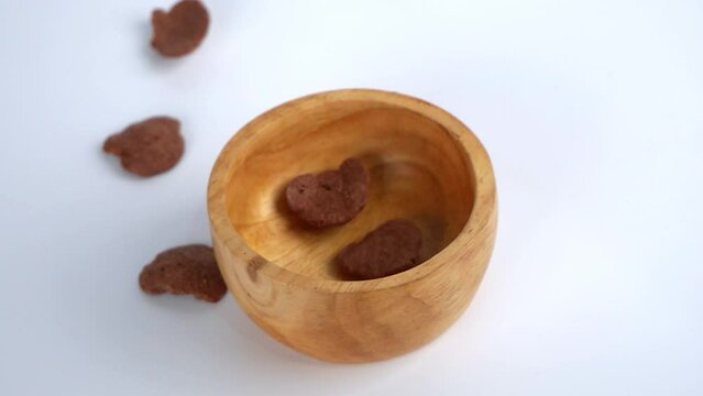 Cereal chocolate falling in wooden small bowll.