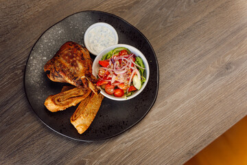 Delicious roasted duck with vegetable salad of cucumbers, greenery, tomato and onion with puff pastry rolls and sauce