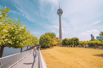 Girl traveler walking by pedestrian footpath bridge over Rhine river, overlooking to famous...