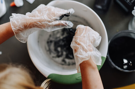 Science Experiment - A Student Wears Latex Gloves And Mixes Iron Oxide Powder With Glue To Create Magnetic Slime