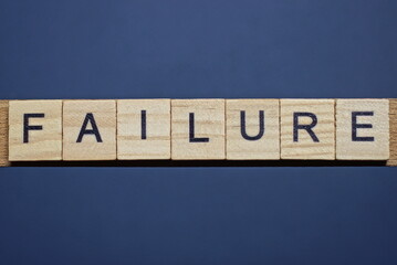 text the word failure from brown wooden small letters on a black table