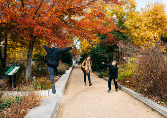 family walks amongst autumn trees in Washington DC