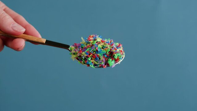Microplastic pollution, plastic particles in spoon close-up, garbage and trash, ecological problems. Global warming and climate changing.
