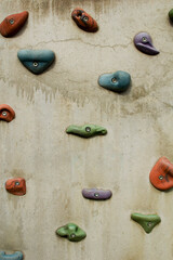 Grey wall with climbing holds.