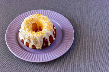 a brown cupcake decorated with white icing on a plate