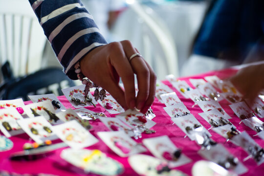 Mano de persona latinoamericana en venta ambulante de accesorios para dama