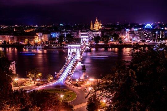 Gorgeous aerial view of Budapest, Hungary at night with vibrant city lights on a bridge over a river