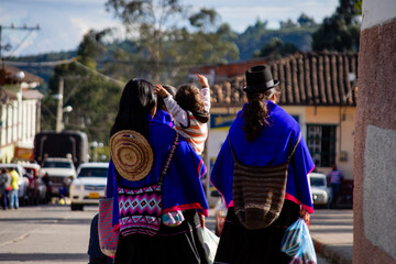 Dos mujeres y un niño indígena de Latinoamérica caminando.