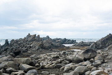 sharp jagged basalt rocks on the sea coast, Cape Stolbchaty on Kunashir Island