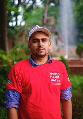 South asian young male medical student wearing red t shirt in awareness about world heart day campaign 