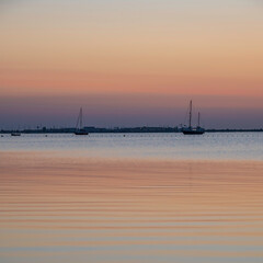 Orange colours of a Mediterranean summers morning, before the sun has risen over the calm sea