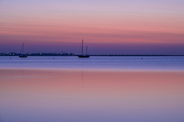 Fototapeta na wymiar Pink colours of a Mediterranean summers morning, before the sun has risen over the calm sea