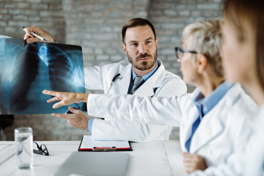 Group of doctors examining X-ray image during a meeting in the office
