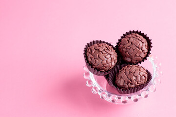 Brigadeiro de chocolate sobre fundo rosa