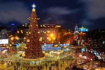 Illuminated Christmas tree, festive decoration and Christmas market on Sophia Square in Kyiv, Ukraine. St. Michael's Golden-Domed Monastery on the background