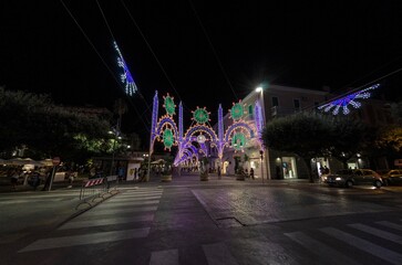 View of an urban landscape with street decorated with illuminations - obrazy, fototapety, plakaty