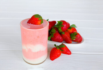 Strawberry yogurt fruit juice smoothie pink colorful fruit juice milkshake blend beverage healthy high protein the taste yummy In glass drink episode morning on white wood background.