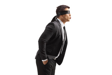 Profile shot of a young man in a suit with blindfold blowing a kiss