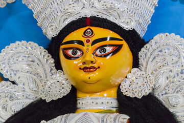 idol of goddess Durga during Durga Puja festival. Hindu deity in traditional white daker saj...