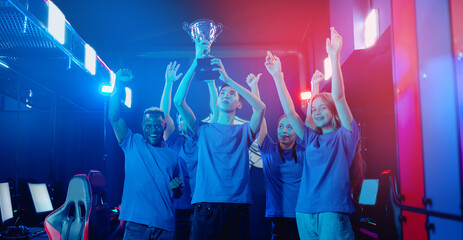 Banner Happy gamer team winner of video games tournament. Holding big cup trophy of victors cyber gaming esport. Soft focus, neon color