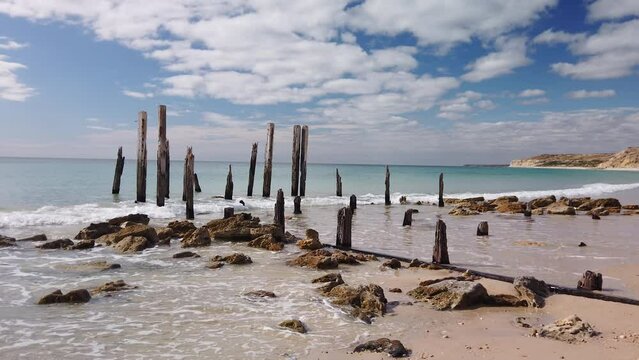 Stationary motion of the ruins and Pylons that Remain of the 1860s jetty on the beach at Port Willunga, south Australia, Australia