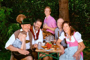 bavarian family sitting outdoors at beer garden having fun