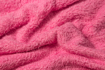 Texture of crumpled fluffy pink material as a background for your image. Soft fabric surface