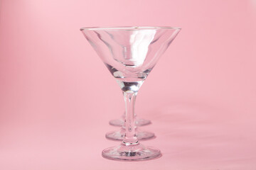 Empty martini glasses on a pink background. Cocktail glasses