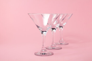 Empty martini glasses on a pink background. Cocktail glasses