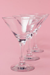 Empty martini glasses on a pink background. Cocktail glasses
