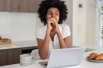 Fototapeta na wymiar Upset woman using laptop, working from home. Young pensive businesswoman thinking, having problems at work or feeling tired. Home office, business, expression concept