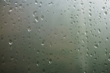 Graue Glasfläche mit Regentropfenmuster