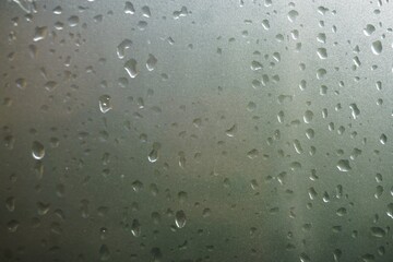 Graue Glasfläche mit Regentropfenmuster