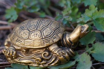 A metal turtle on a background of green grass.