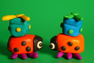 A pair of ladybugs with gifts on a green background. Decorations for the holiday.