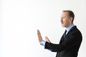 Worried mature businessman protecting himself with hands. Side view of senior Caucasian manager...