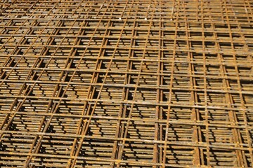 Goldbraune Eisengitterlatten auf Baustelle bei Sonne am Mittag im Sommer