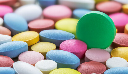 Selective focus on white pills on the background of pills of different colors. Antibiotic...